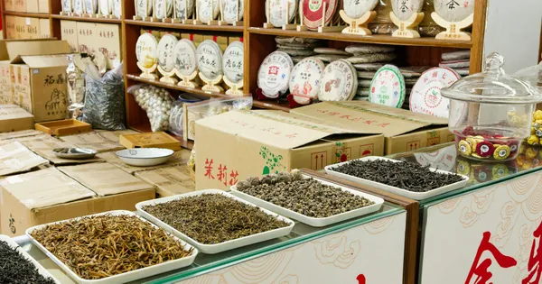Plantas secas y tés expuestos en bandejas en una tienda de productos herbales de Pekín, China